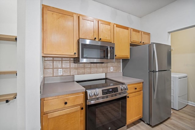 kitchen with decorative backsplash, light brown cabinetry, light hardwood / wood-style floors, washer / dryer, and stainless steel appliances