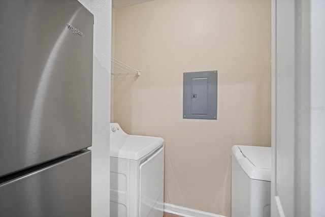 laundry room featuring electric panel and separate washer and dryer