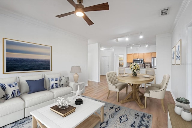 living room with wood-type flooring, ceiling fan, and crown molding