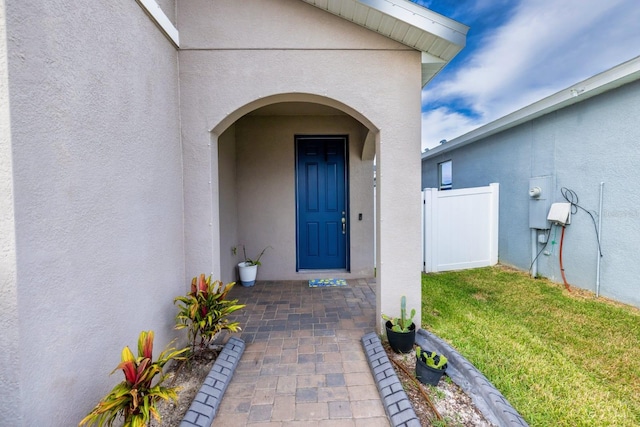 entrance to property featuring a lawn