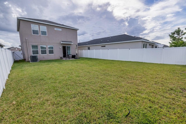 back of house featuring a lawn and central air condition unit