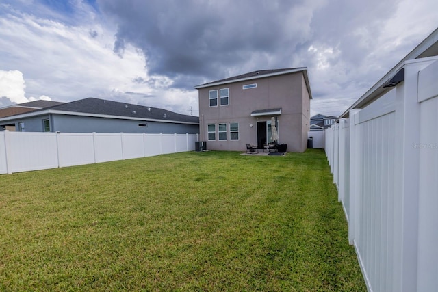 rear view of property with a yard and cooling unit