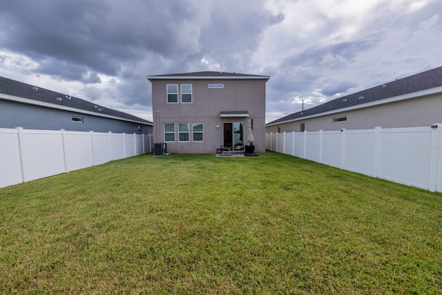 rear view of house featuring central AC, a patio area, and a lawn