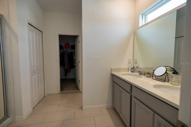 bathroom featuring tile patterned flooring, vanity, and a shower with shower door