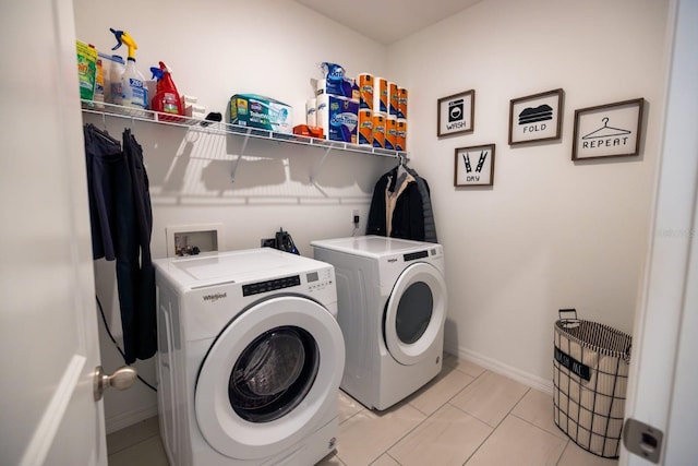 clothes washing area featuring light tile patterned floors and washing machine and dryer