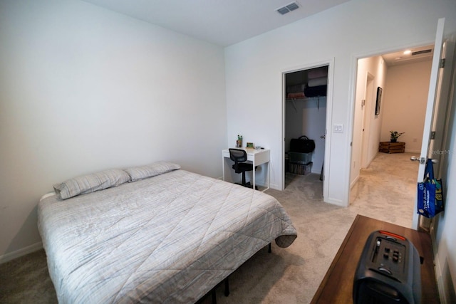 bedroom featuring light carpet, a walk in closet, and a closet