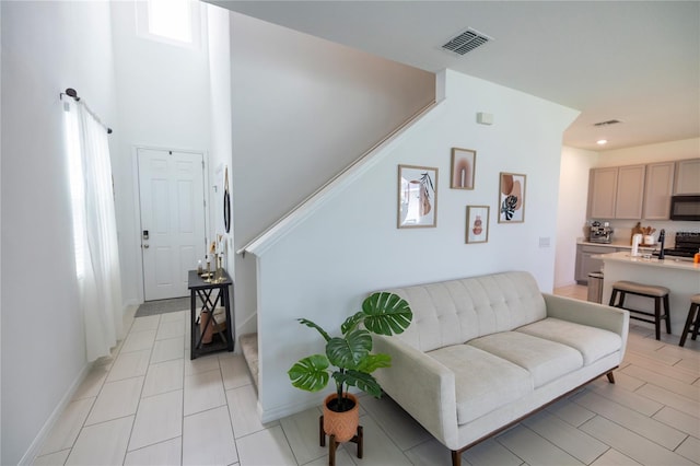 11834 Brighton Knoll Loop, Riverview, FL 33579 - living room with stairway, recessed lighting, light tile patterned flooring, and a towering ceiling