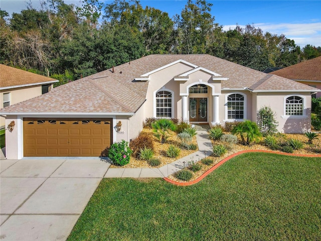 single story home featuring a garage, a front yard, and french doors