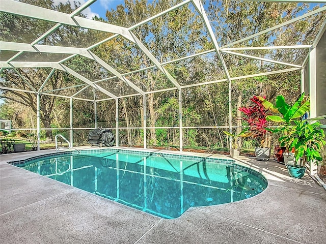 view of pool with glass enclosure and a patio