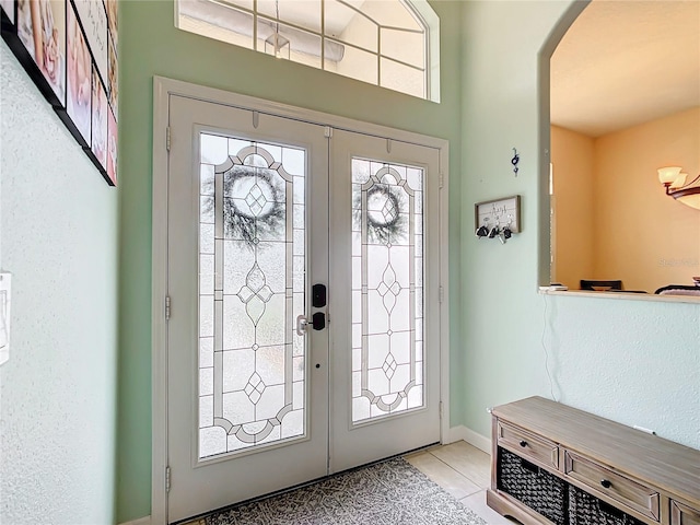 tiled foyer with french doors and a healthy amount of sunlight