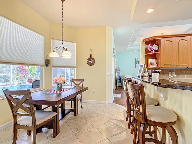 dining space with a chandelier, light tile patterned floors, and sink