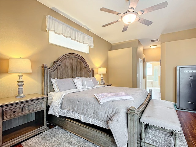 bedroom featuring multiple windows, dark hardwood / wood-style flooring, ensuite bathroom, and ceiling fan