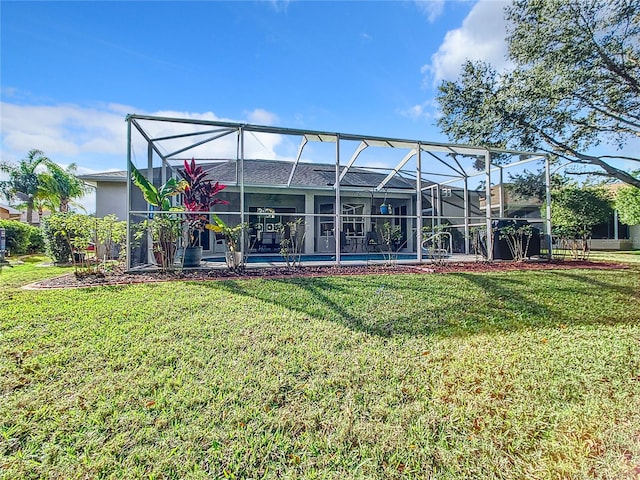 back of house featuring glass enclosure and a yard