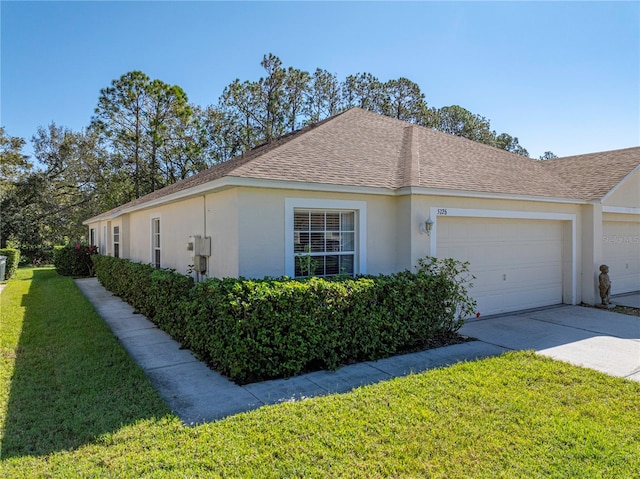 view of side of home with a lawn and a garage