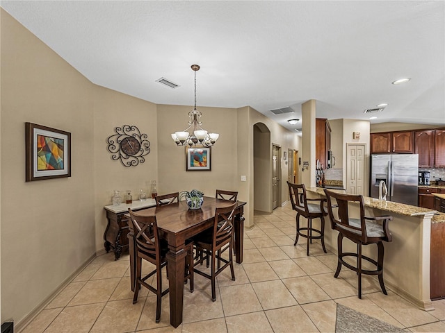 tiled dining space with an inviting chandelier