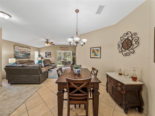 tiled dining room featuring vaulted ceiling and ceiling fan with notable chandelier