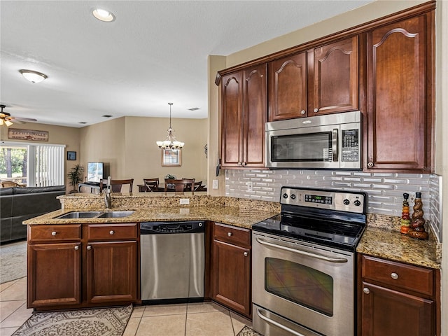 kitchen with sink, kitchen peninsula, stainless steel appliances, and hanging light fixtures