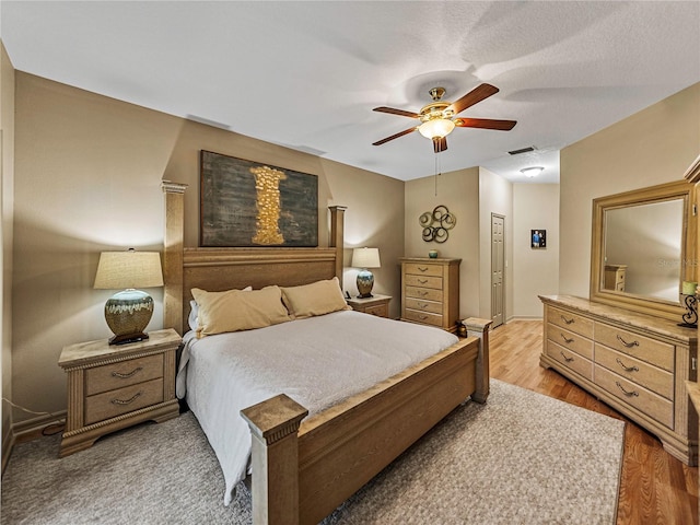 bedroom with a closet, hardwood / wood-style flooring, and ceiling fan