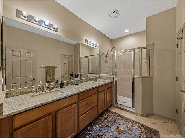 bathroom featuring tile patterned flooring, vanity, and walk in shower