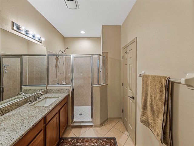 bathroom with tile patterned flooring, vanity, and a shower with door