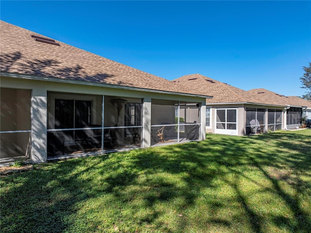 rear view of house with a sunroom and a lawn