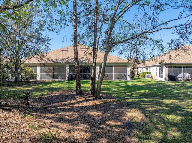 rear view of house with a sunroom and a yard