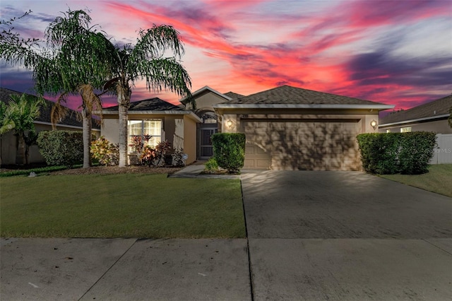 view of front of property with a garage and a lawn