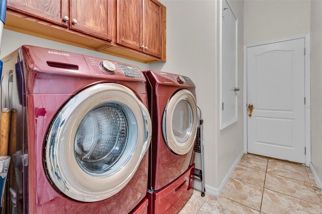 washroom featuring separate washer and dryer, light tile patterned flooring, and cabinets