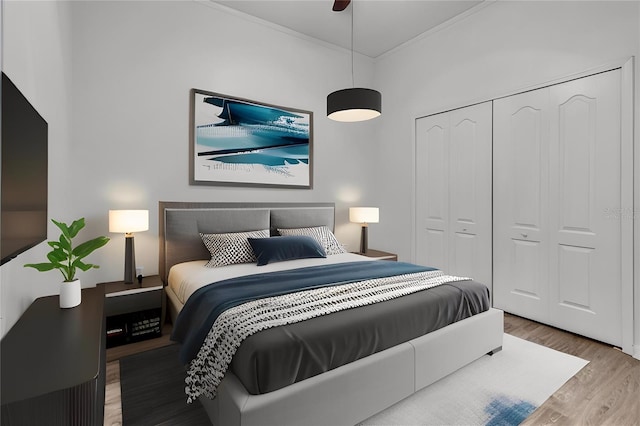 bedroom featuring hardwood / wood-style flooring, ceiling fan, ornamental molding, and a closet