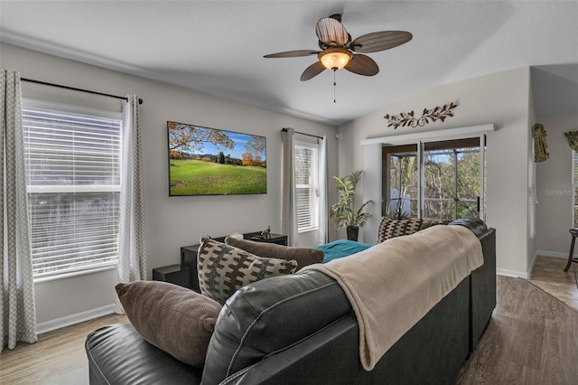 living room with ceiling fan, lofted ceiling, and light hardwood / wood-style flooring