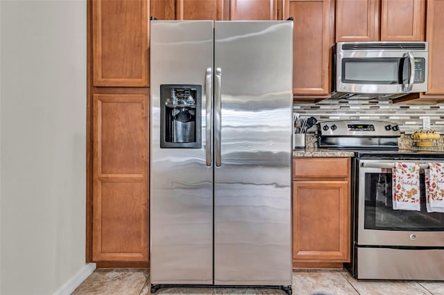 kitchen featuring light tile patterned floors, stainless steel appliances, and tasteful backsplash