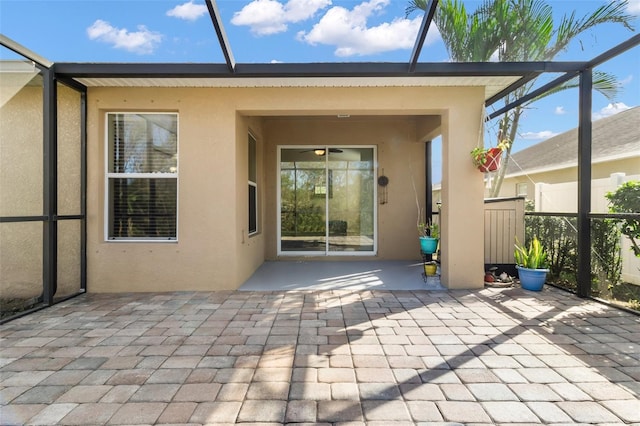 back of property with glass enclosure and a patio area