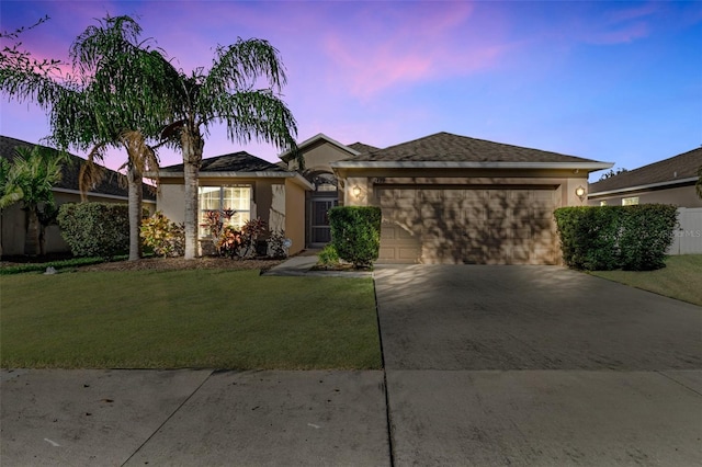 single story home featuring a yard and a garage