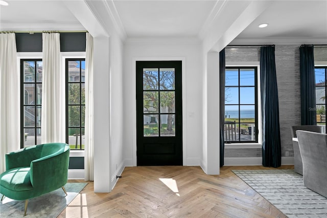 foyer entrance with light parquet floors and ornamental molding