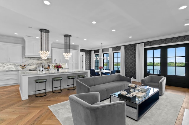 living room featuring crown molding, plenty of natural light, a water view, and light parquet floors