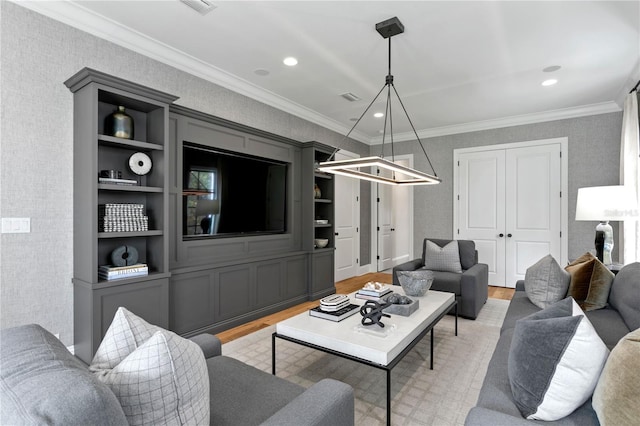 living room with light hardwood / wood-style floors, built in features, and crown molding