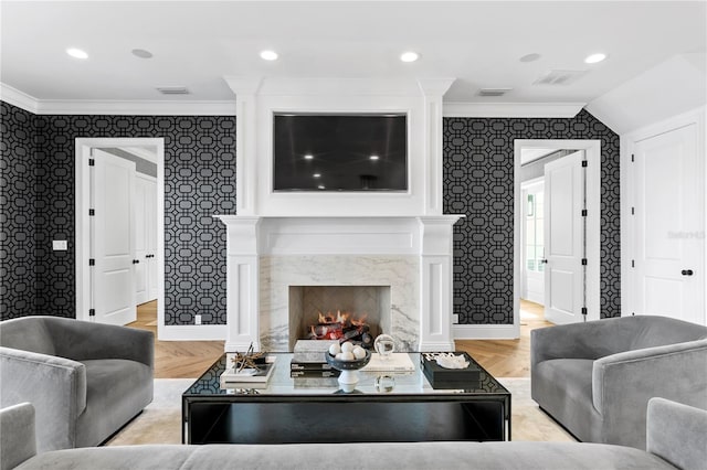 living room featuring vaulted ceiling, crown molding, a fireplace, and light hardwood / wood-style flooring