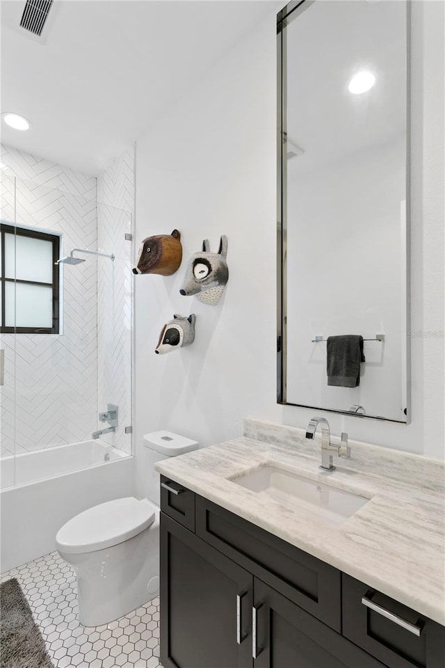 full bathroom featuring tile patterned floors, vanity, toilet, and tiled shower / bath