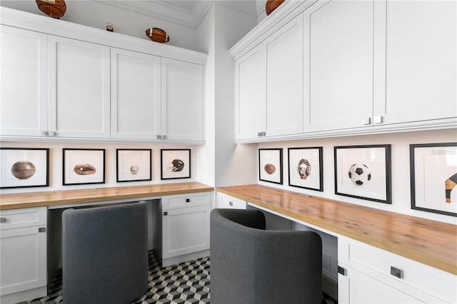 home office with built in desk and crown molding