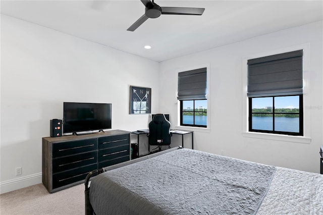 carpeted bedroom featuring ceiling fan and multiple windows