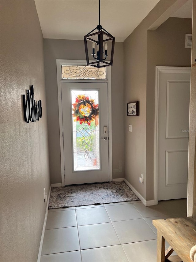 entrance foyer featuring light tile patterned flooring and an inviting chandelier