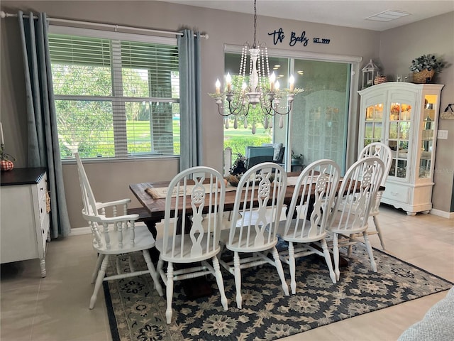 dining area with light tile patterned floors and an inviting chandelier