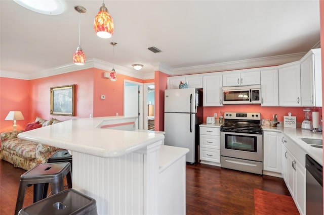 kitchen featuring dark wood-type flooring, a kitchen breakfast bar, decorative light fixtures, white cabinetry, and stainless steel appliances