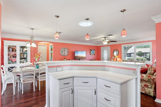 kitchen with pendant lighting, dark hardwood / wood-style floors, white cabinetry, and crown molding