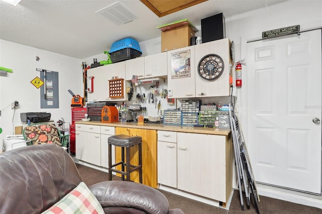 kitchen featuring dark colored carpet, butcher block countertops, white cabinetry, and a textured ceiling