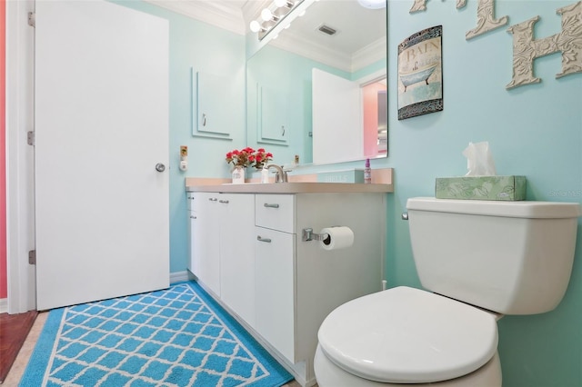 bathroom featuring hardwood / wood-style flooring, toilet, vanity, and ornamental molding