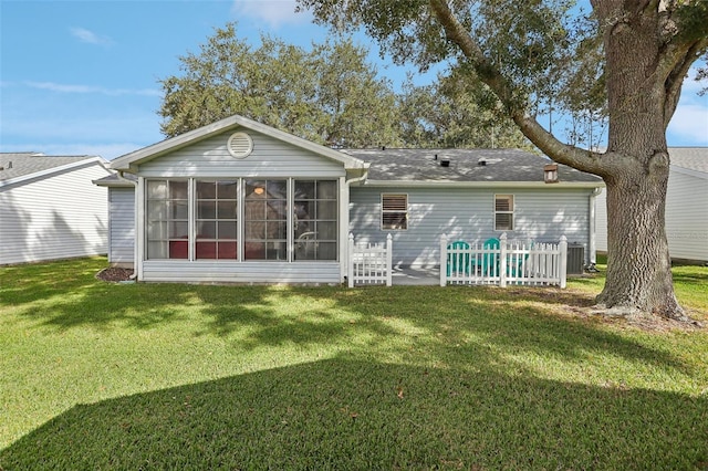 back of property featuring a lawn and a sunroom