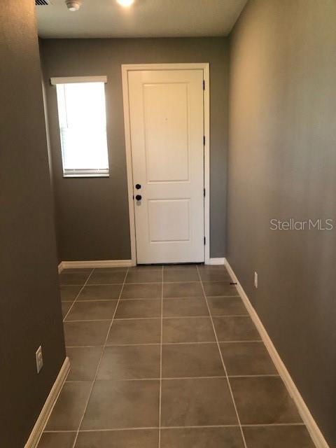 entryway with dark tile patterned floors