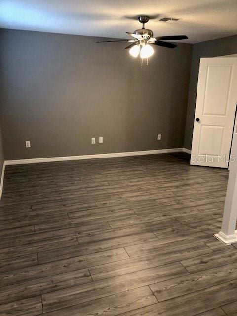 unfurnished room featuring dark wood-type flooring and ceiling fan