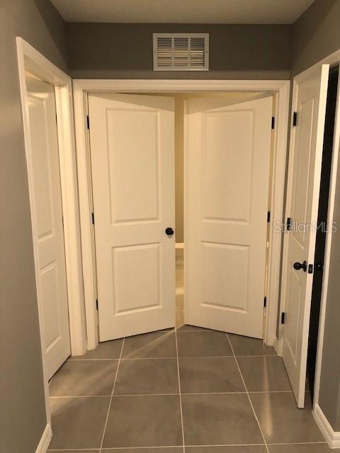 hallway featuring dark tile patterned floors